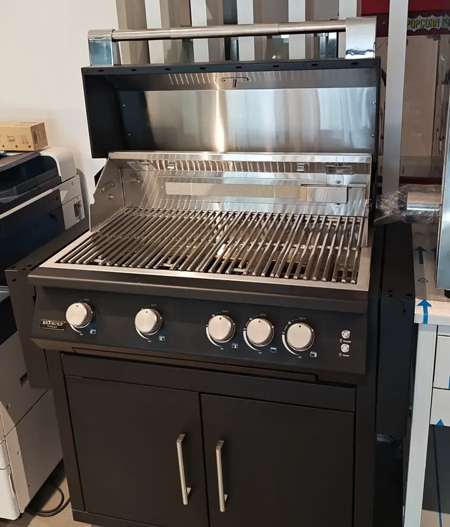 Brabura Grills four-burner gas barbecue with matt black cabinet body and analogue lid thermometer, shown in the Spiteri Catering showroom