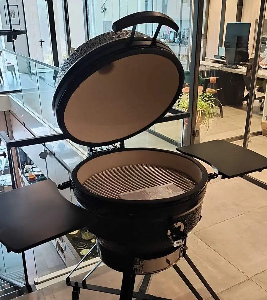Maximus ceramic kamado with side shelves extended, showing the adjustable top vent and thermometer integrated into the lid