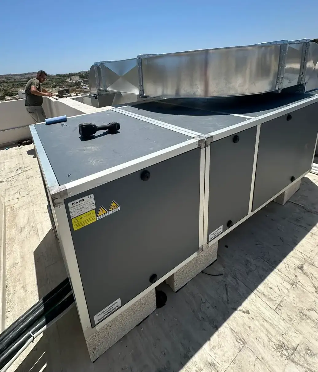 Custom extraction ductwork descending through the building at Casa Giuseppe, Gozo, with the Citadel of Victoria visible on the hilltop behind