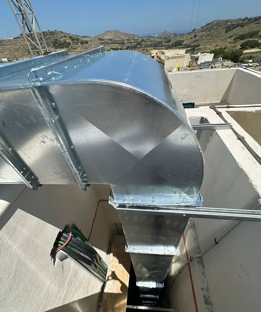 Completed rooftop extraction installation at Casa Giuseppe with custom curved ductwork transitions and Victoria skyline behind