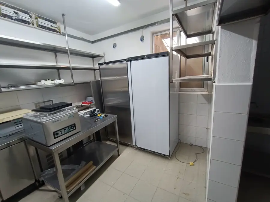 Combisteel upright refrigeration cabinet and stainless steel shelving in the prep area at Joe's Street Pizza kitchen
