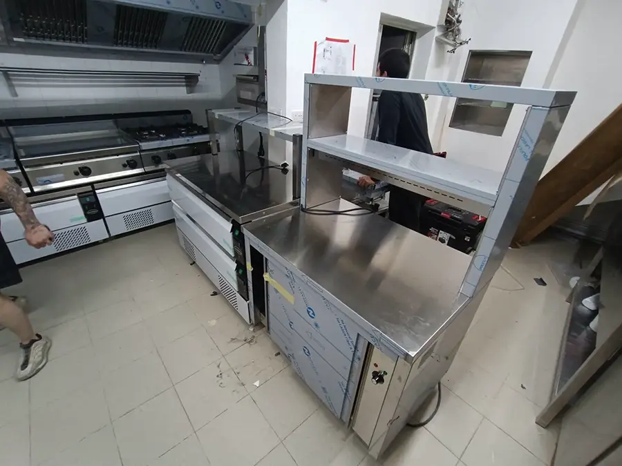Combisteel under-equipment counters and pizza prep counter being positioned during fit-out at Joe's Street Pizza kitchen