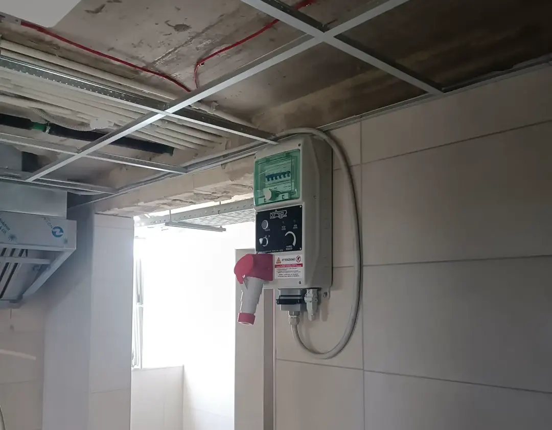 Spiteri Catering installation team positioning a stainless steel extraction canopy during a commercial kitchen fit-out