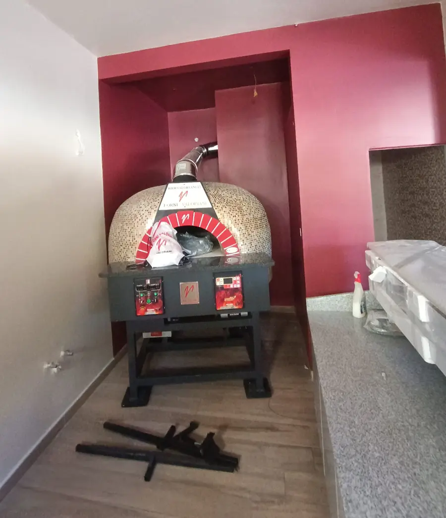 The installed Valoriani Rotante 100 pizza oven at Joe's Street Pizza, Nadur, showing the mosaic-tiled dome and red-tiled arch within its red-painted alcove