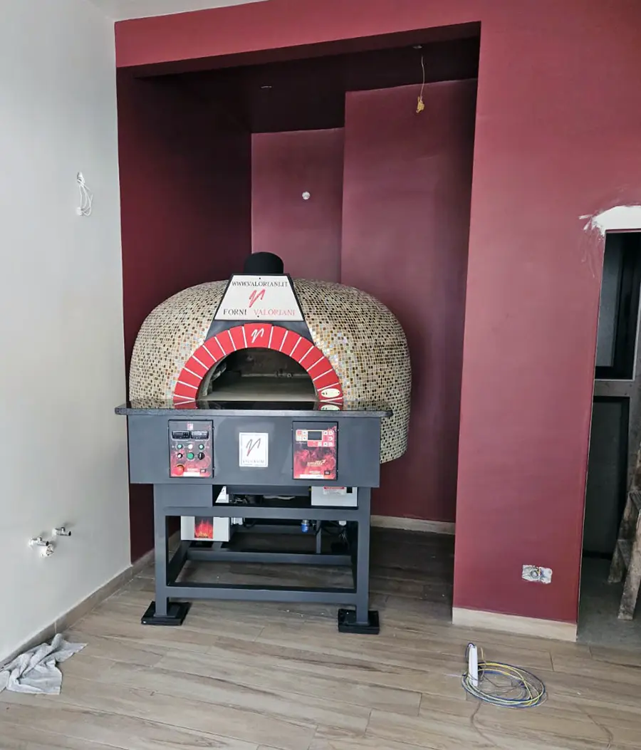 Rooftop flue termination and extraction unit serving the Valoriani oven at Joe's Street Pizza, Nadur, with a polished stainless steel chimney against a blue sky